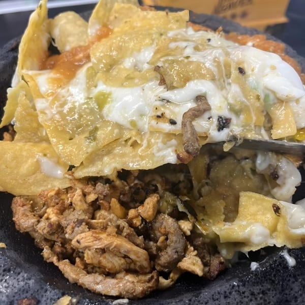 Close-up of La Cantina's Mexican nachos with melted cheese, salsa, and seasoned meat.
