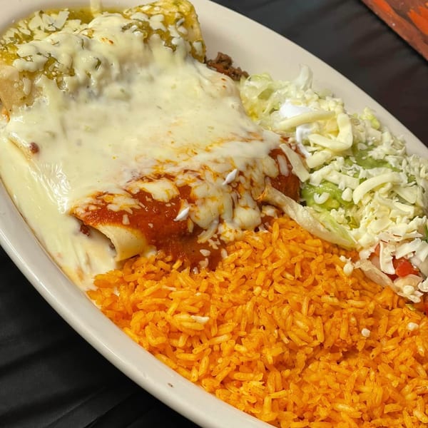 A plate of La Cantina's Mexican food, featuring enchiladas with red and green sauce, rice, and salad.